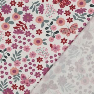 Tissu french terry blanc avec motif de petites fleurs roses, rouges et corail, feuillages verts sauge et papillons décoratifs dans des tons rosés.