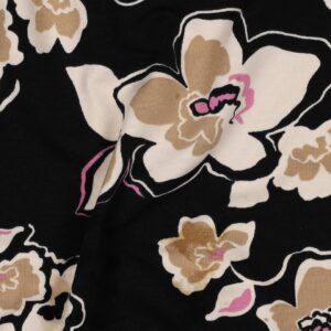 Tissu french terry noir avec grandes fleurs stylisées beige, crème et touches de rose, motif élégant et contrasté.