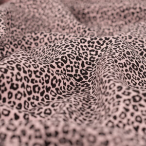 Tissu jersey de coton motif mini léopard noir sur fond rose poudré