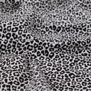 Tissu jersey de coton motif mini léopard noir sur fond écru